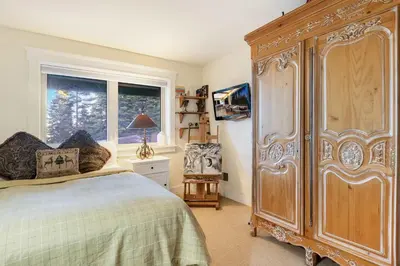 a bedroom with a large wooden cabinet next to a window at Carnelian Bay Getaway in Carnelian Bay