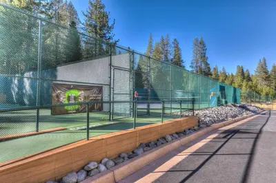 a tennis court inside of a fence with a tennis court at Cedar Chateau with Game Room & HOA Access in Truckee