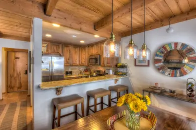 a kitchen with wooden cabinets and a table with chairs at Granlibakken Retreat Near Tahoe Beach in Tahoe City