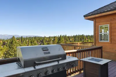 a grill on a balcony with a view of a forest at Hilltop Hideaway w Game Room & Forest Views in Truckee