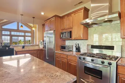 a kitchen with stainless steel appliances and wooden cabinets at Hilltop Hideaway w Game Room & Forest Views in Truckee