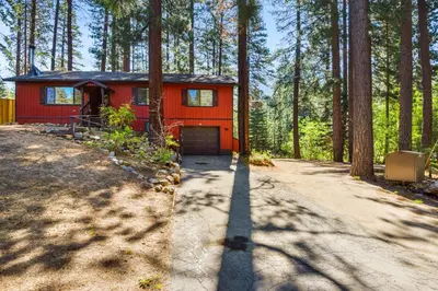 a red house in the middle of a forest at Incline Bliss Dreamy Pet Friendly Escape in Incline Village