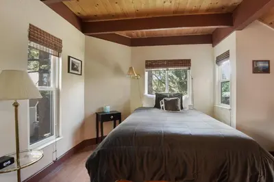 a bedroom with a large bed and two windows at Tahoe City Getaway Minutes from Lake and Activities in Tahoe City