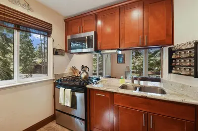a kitchen with a stove and a sink and windows at Tahoe City Getaway Minutes from Lake and Activities in Tahoe City