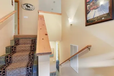 a staircase in a house with a clock on the wall at Kings Beach Bliss Walk to Outdoor Fun in Kings Beach