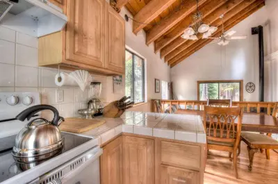 a kitchen with wooden cabinets and a stove top oven at Glacier Forest Getaway HOA Access in Truckee
