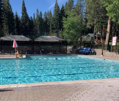 a large swimming pool with a person in the water at A Golden Getaway Pool Hot Tub Tennis & More in Truckee