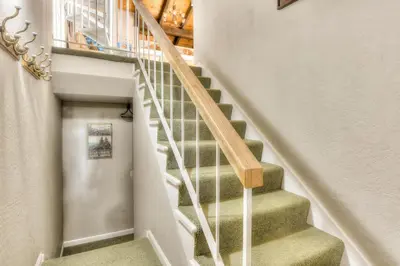 a staircase in a home with green carpet and wooden railings at Lake Forest Villa Patio w BBQ in Tahoe City