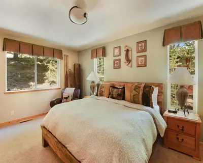 a bedroom with a large bed and two windows at Lux Leisure Game Room & More in Truckee