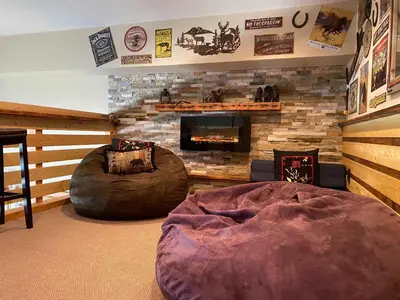 a living room with a fireplace and a large bed at Lux Leisure Game Room & More in Truckee