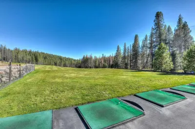 an image of a golf course with green grass and trees at Lux Leisure Game Room & More in Truckee