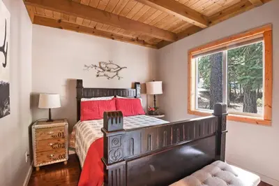 a bedroom with a bed with red pillows and a window at Luxury Tahoe Chalet Minutes to Dining in Tahoe Vista