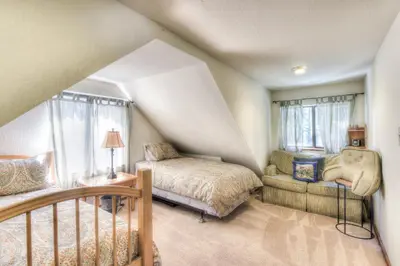 a bedroom with a bed and a chair in a attic at Moonlight Cove w Grill Tahoe Beach Next Door in Tahoe Vista