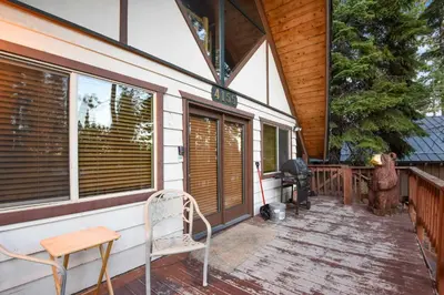 a porch of a house with a chair and windows at Moose Cabin Year Round Outdoor Fun w BBQ in Carnelian Bay