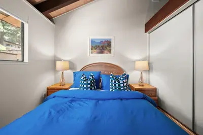 a bedroom with a blue bed and two lamps at Mountain Shadows Chalet Tahoe Fun Awaits in Incline Village