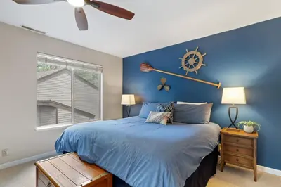a bedroom with a bed with a nautical clock on the wall at Family Fun Getaway - 3 Story Condo in Zephyr Cove