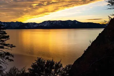 a sunset over a large body of water with mountains at Heaven's Nest - the BEST views of Lake Tahoe in Stateline