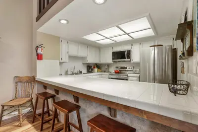 a kitchen with a large white counter and a refrigerator at Heavenly Haven - Hot Tub and Seasonal HOA Pool in Zephyr Cove