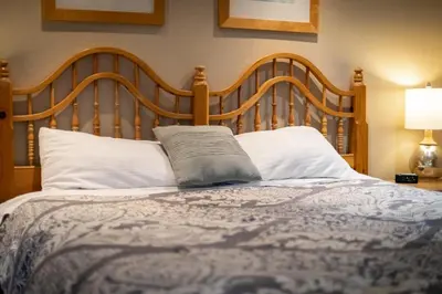 a bed with a wooden headboard and white pillows at Heavenly Haven - Hot Tub and Seasonal HOA Pool in Zephyr Cove