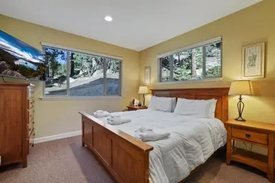 a bedroom with a large bed and two windows at Heavenly Mountain Chalet - Skiing Pets Hot tub in Stateline
