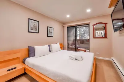 a bedroom with a large white bed with a window at Lakeland Getaway - Walk to Lake in South Lake Tahoe