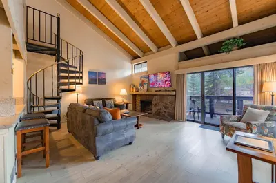 a living room with a couch and a staircase at Lakeland Sandy Beach Retreat - Private Escape in South Lake Tahoe