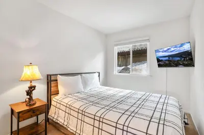 a bedroom with a bed and a lamp on a table at Mile High Mountain - Carson Valley Views in Stateline