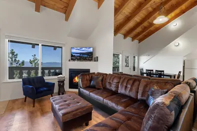 a living room with a leather couch and a fireplace at Mile High Mountain - Carson Valley Views in Stateline
