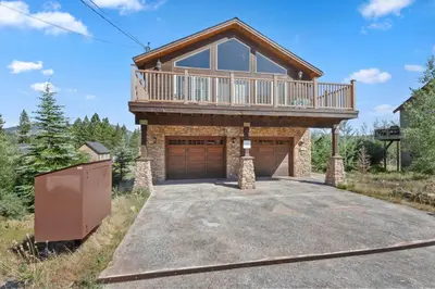 a house with a balcony on top of a driveway at Mule Meadows - Classy Split level South Tahoe home in South Lake Tahoe