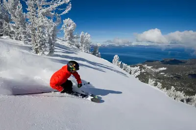 a person riding a snowboard down a snow covered slope at Mule Meadows - Classy Split level South Tahoe home in South Lake Tahoe