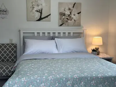 a bedroom with a bed and two pictures on the wall at Private Suites in Sacramento