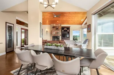 a dining room with a black table and white chairs at Yosemite Cloudline Ridge in Oakhurst