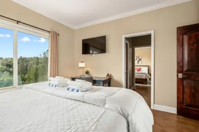 a bedroom with a large white bed with a window at Yosemite Cloudline Ridge in Oakhurst