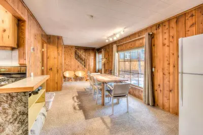 a kitchen with a table and chairs and a refrigerator at Badger Basin - 30 Days or more Vacation Home Rental in South Lake Tahoe