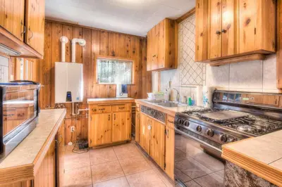 a kitchen with wooden cabinets and a stove at Badger Basin - 30 Days or more Vacation Home Rental in South Lake Tahoe