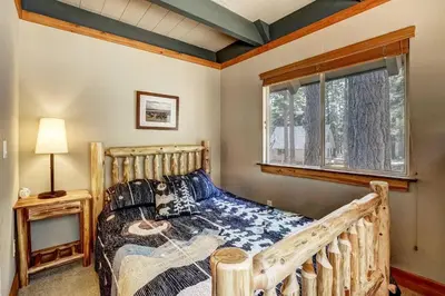 a bedroom with a wooden bed and a window at Bear Pause 4BR - Large Deck & Balcony in South Lake Tahoe