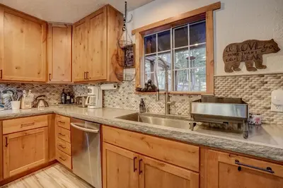 a kitchen with wooden cabinets and a sink at The Blue Lake House - Family fun Abound in South Lake Tahoe