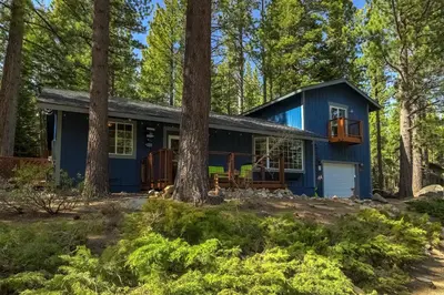 a blue house in the woods with trees at The Blue Lake House - Family fun Abound in South Lake Tahoe