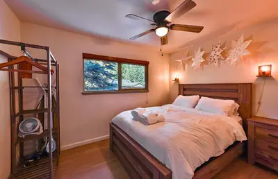 a bedroom with a bed with a ceiling fan at Charming Cherokee Cabin - Secluded Stay for 6 Just 10 Minutes to Tahoe in South Lake Tahoe