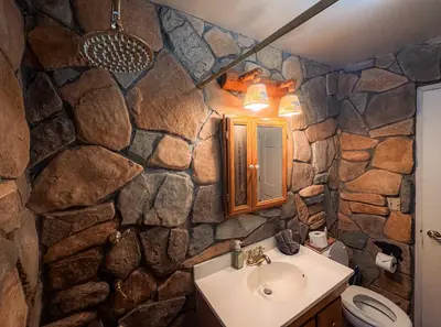 a stone bathroom with a sink and a toilet at Charming Cherokee Cabin - Secluded Stay for 6 Just 10 Minutes to Tahoe in South Lake Tahoe