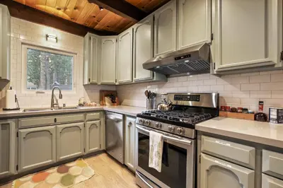 a kitchen with stainless steel appliances and white cabinets at Christmas Valley Chalet - Tahoe Adventure Awaits in South Lake Tahoe