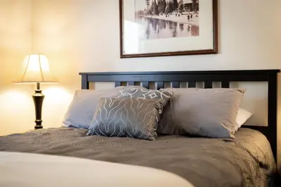 a bedroom with a bed with two pillows and a lamp at Coziness Cabin - Cute little cabin in the Tahoe woods in South Lake Tahoe