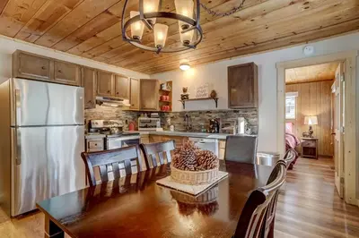 a kitchen with a dining table and a refrigerator at Come Snuggle Up at Cozy Bear Cabin in South Lake Tahoe