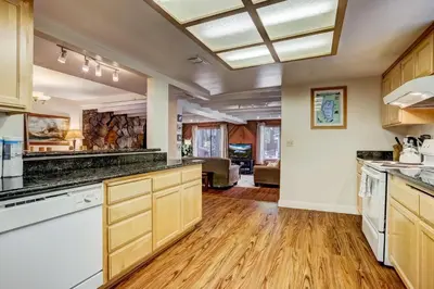 an open kitchen with wooden cabinets and wooden floors at Paloma Place Lakeview Home Hot Tub Game Room in South Lake Tahoe