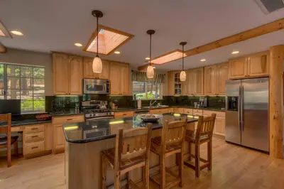 a large kitchen with wooden cabinets and stainless steel appliances at Prima Del Norte - Hot tub Pool Table Arcade Game in South Lake Tahoe