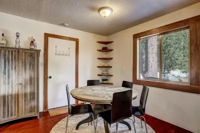 a dining room with a table and chairs and a window at Rustic Haven - Hot tub & Pet friendly in South Lake Tahoe