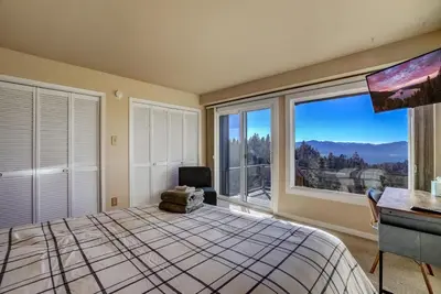 a bedroom with a bed and a desk and a large window at Scenic Escape - BEST views of Lake Tahoe in Stateline