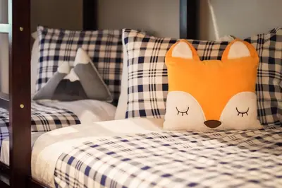 a pillow shaped like a fox sitting on a bed at It's a Sierra State of Mind - Family Fun in South Lake Tahoe