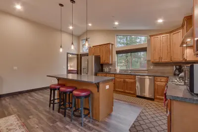 a kitchen with wooden cabinets and a island with bar stools at Silver Pines - Ski or Summer 30 plus day home in South Lake Tahoe