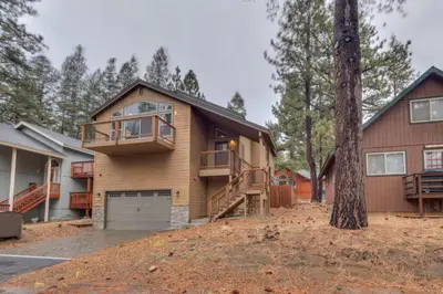 a house with a garage and a tree at Silver Pines - Ski or Summer 30 plus day home in South Lake Tahoe